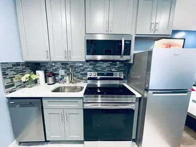 a kitchen with white cabinets and a stainless steel refrigerator at Rittenhouse Square near Kimmel Center Studio Suite in Philadelphia