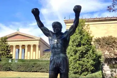 a statue of a man with his arms in the air at Rittenhouse Square near Kimmel Center Studio Suite in Philadelphia