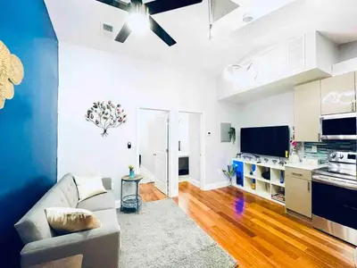 a living room with a couch and a kitchen at Vibrant 1BD Suite in Downtown Center City in Philadelphia