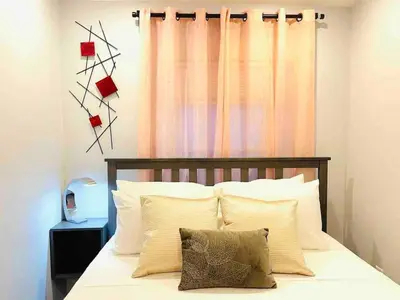 a bedroom with a bed with white pillows and a window at Vibrant 1BD Suite in Downtown Center City in Philadelphia