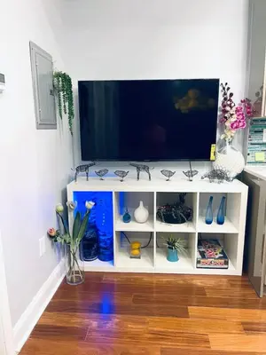 a white entertainment center with a flat screen tv at Vibrant 1BD Suite in Downtown Center City in Philadelphia