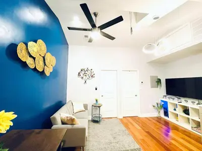 a living room with a blue wall with a ceiling fan at Vibrant 1BD Suite in Downtown Center City in Philadelphia