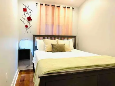a bedroom with a bed with white sheets and a window at Vibrant 1BD Suite in Downtown Center City in Philadelphia