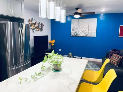 a kitchen with a table with yellow chairs and a refrigerator at Magic Gardens 1BD Apt in Center City in Philadelphia