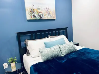 a blue bedroom with a bed with pillows on it at Magic Gardens 1BD Apt in Center City in Philadelphia