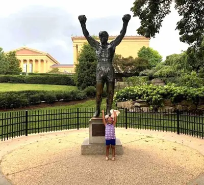 a little girl standing in front of a statue at Magic Gardens 1BD Apt in Center City in Philadelphia