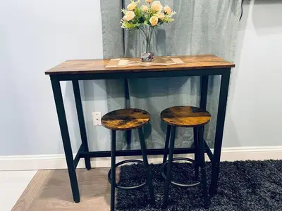 a table with two stools and a vase of flowers at Rittenhouse Square near Kimmel Center Studio in Philadelphia