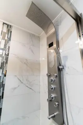 a shower with a glass door and marble walls at Rittenhouse Square near Kimmel Center Studio in Philadelphia