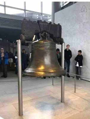 a large bronze bell on display in a building at Rittenhouse Square near Kimmel Center Studio in Philadelphia