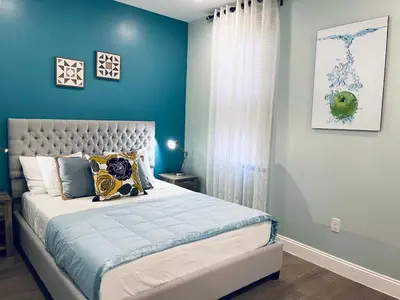 a bedroom with a large bed with blue walls at Rittenhouse Square near Kimmel Center 1BD Suite in Philadelphia