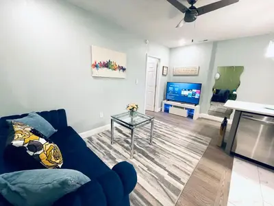 a living room with a blue couch and a tv at Rittenhouse Square near Kimmel Center 1BD Suite in Philadelphia