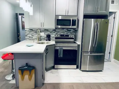 a kitchen with white cabinets and stainless steel appliances at Rittenhouse Square near Kimmel Center 1BD Suite in Philadelphia