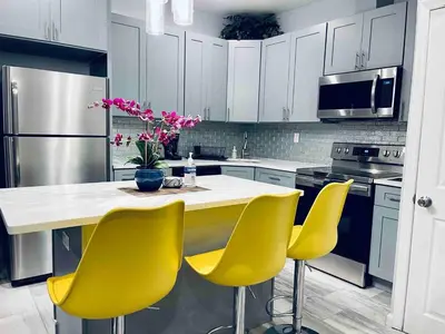 a kitchen with yellow chairs and a white counter top at Lovely Beautiful 2BR Apt in Center City in Philadelphia