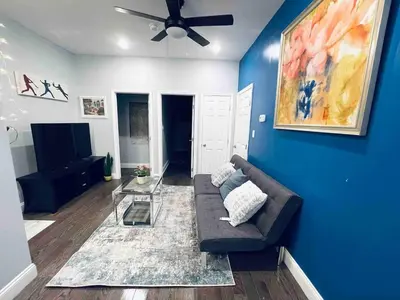 a living room with a couch and a blue wall at Lovely Beautiful 2BR Apt in Center City in Philadelphia