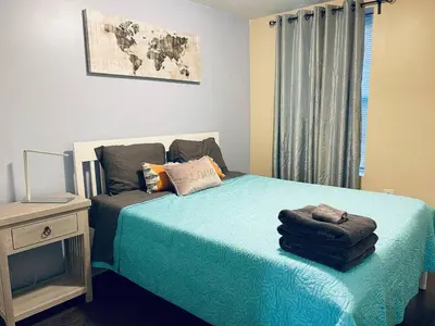 a bedroom with a bed with blue sheets and a window at Cozy Beautiful 2BD Apt in Center City in Philadelphia