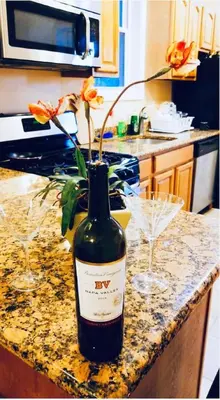 a bottle of wine sitting on a counter with a flower at Modern Home w. Deck in Passyunk Square in Philadelphia