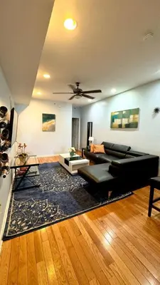 a living room with a black couch and a rug at Modern Home w. Deck in Passyunk Square in Philadelphia