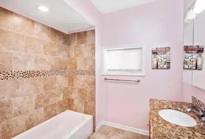a bathroom with a white tub and a sink at Modern Home w. Deck in Passyunk Square in Philadelphia