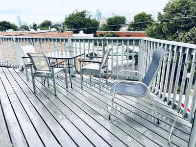 a deck with a table and chairs on a balcony at Beautiful 1BD Apt with Roofdeck in Passyunk Square in Philadelphia