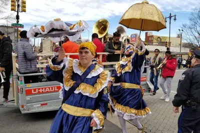 a group of people walking down a street in a parade at Beautiful 1BD Apt with Roofdeck in Passyunk Square in Philadelphia