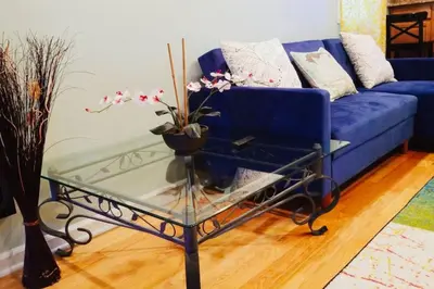 a blue couch and a glass coffee table in a living room at Beautiful 1BD Apt with Roofdeck in Passyunk Square in Philadelphia