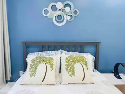 a bed with white pillows with trees on it at Downtown City Hall near Rittenhouse Square 1 BD in Philadelphia