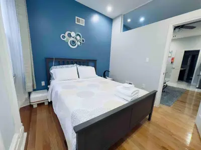 a bedroom with a large bed and a blue wall at Downtown City Hall near Rittenhouse Square 1 BD in Philadelphia