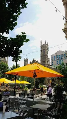 a group of tables and chairs under a yellow umbrella at Downtown City Hall near Rittenhouse Square 1 BD in Philadelphia