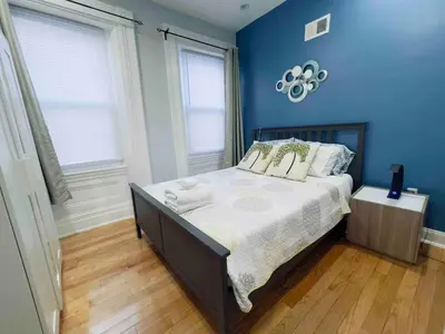 a bedroom with a bed with blue walls and wooden floors at Downtown City Hall near Rittenhouse Square 1 BD in Philadelphia