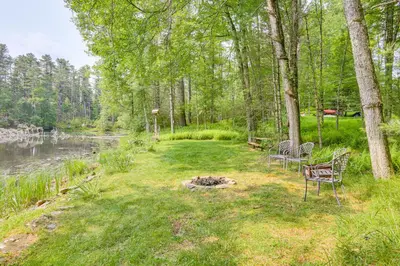 a group of chairs sitting in the grass near a pond at Waterfront Studio with Loft and Dock Near Narrowsburg! in Narrowsburg
