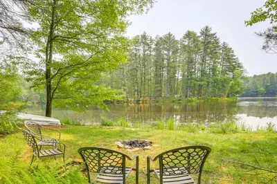a group of chairs sitting next to a lake at Waterfront Studio with Loft and Dock Near Narrowsburg! in Narrowsburg
