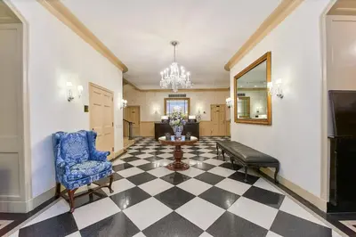 a lobby with a table and a blue chair and a mirror at 3 West Club in New York