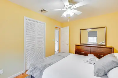 a bedroom with a bed with a ceiling fan and a mirror at 4 Mi to Hudson River Cozy Newburgh Home! in Newburgh
