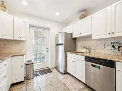 a kitchen with white cabinets and a stainless steel refrigerator at The Prime in Philadelphia