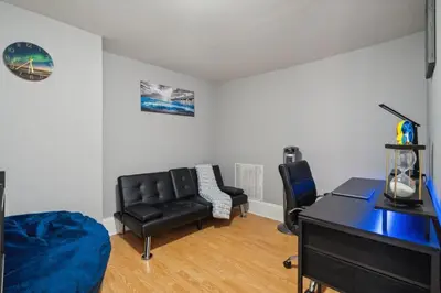 a living room with a black leather couch and a desk at The Prime in Philadelphia