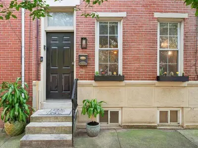 a brick house with a black door and two windows at The Prime in Philadelphia