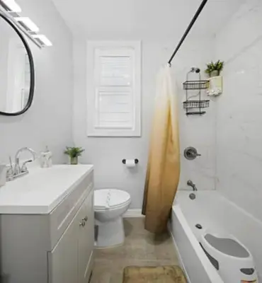 a white bathroom with a toilet and a sink at Music - Big 3br with King Bd Close to EWR and NYC in Bayonne