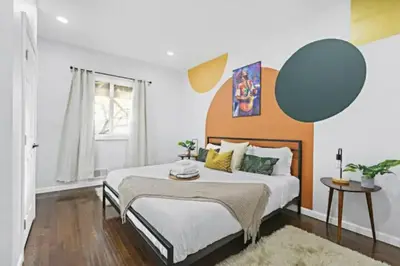 a bedroom with a large bed with an orange headboard at Music - Big 3br with King Bd Close to EWR and NYC in Bayonne
