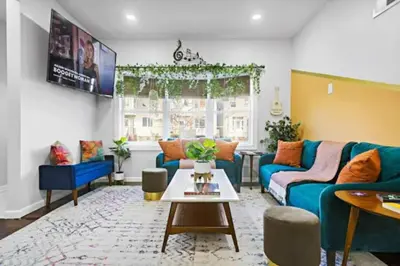 a living room with a blue couch and a table at Music - Big 3br with King Bd Close to EWR and NYC in Bayonne