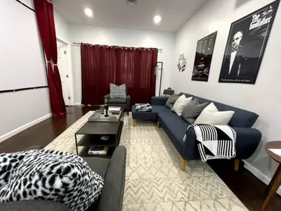 a living room with a blue couch and a table at Movie - 4 bedroom with King bed, deck and 80 in Movie Screen in Bayonne
