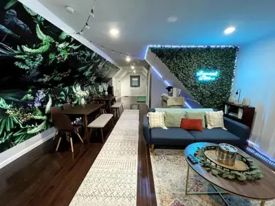 a living room with a blue and green wall at Duplex apt - Dining - 80in Projector - Pool Table in Bayonne