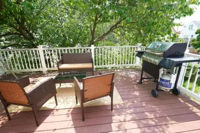 a patio with a grill and a piano on a deck at Duplex apt - Dining - 80in Projector - Pool Table in Bayonne