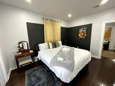 a bedroom with a large white bed and a table at Duplex apt - Dining - 80in Projector - Pool Table in Bayonne