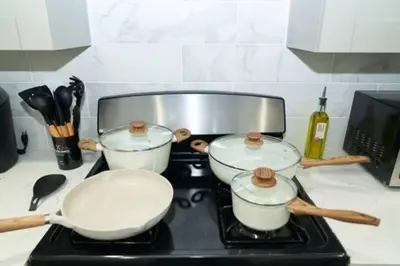 a stove top with three pots and pans on it at 2 Living Rooms - King bd - Deck - BBQ - Airport 15 min in Bayonne