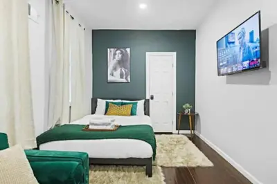 a bedroom with a bed and a flat screen tv at 2 Living Rooms - King bd - Deck - BBQ - Airport 15 min in Bayonne