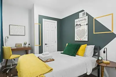 a bedroom with a bed and a desk and a chair at 2 Living Rooms - King bd - Deck - BBQ - Airport 15 min in Bayonne