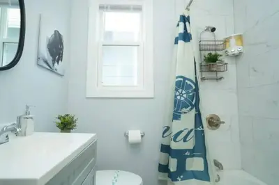 a bathroom with a toilet and a shower curtain at 2 Living Rooms - King bd - Deck - BBQ - Airport 15 min in Bayonne