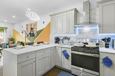 a kitchen with white cabinets and a stove top oven at W3S - Large 7br 3bath - Sleeps 20 - 3 Living rooms - Yard and Deck in Bayonne