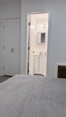 a bedroom with a white bed and a bathroom at Beautiful Bedroom with Attached Bathroom, 15 minutes from NYC in West New York