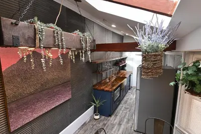 a lobby with a bar and plants on the wall at BurgBnB Downtown in Harrisburg